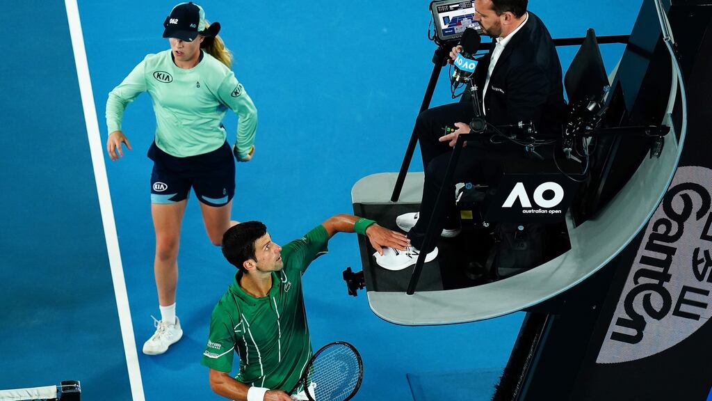 Novak Djokovic taps chair umpire Damien Dumusois on the foot after receiving a time violation during the men’s singles final against Dominic Thiem at the Australian Open. Photograph: Dave Hunt/EPA