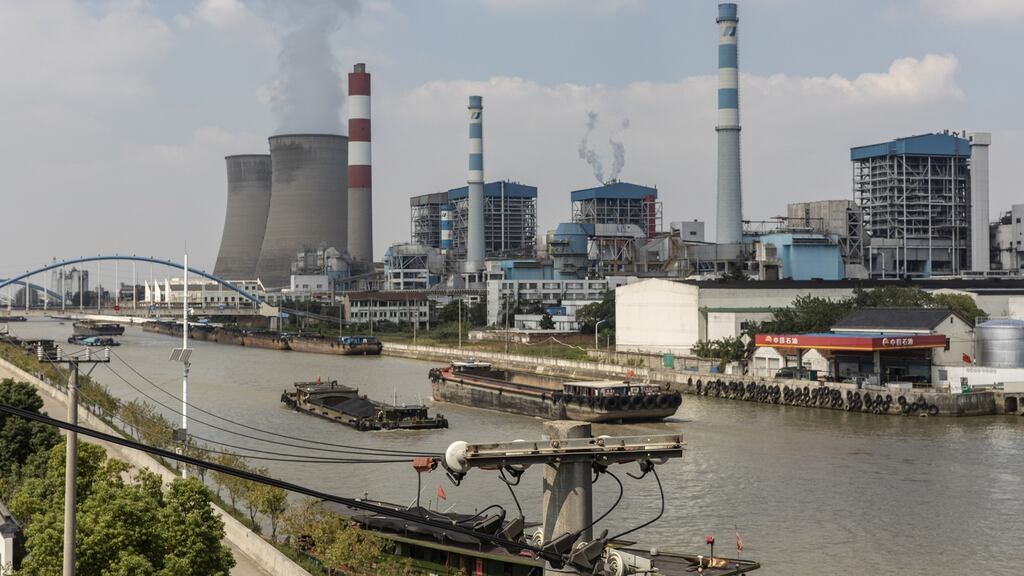 Barges travel past the Wangting Power Plant in Wangting, Jiangsu province, China. China’s central government officials ordered the country’s top state-owned energy companies -- from coal to electricity and oil -- to secure supplies for this winter at all costs, according to people familiar with the matter. Photographer: Qilai Shen/Bloomberg