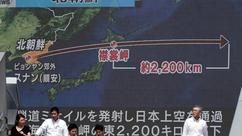 People walk past a public TV screen broadcasting news of North Korea’s launch of a missile, in Tokyo on Friday. The missile flew over Japan’s northern island of Hokkaido. Photograph: Eugene Hoshiko/AP