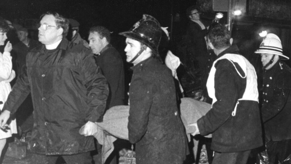 A priest helps rescue workers carry the body of one of the 15 people killed in the loyalist bombing  at McGurks’ pub in  Belfast in December 1971.  Photograph: Pat Langan