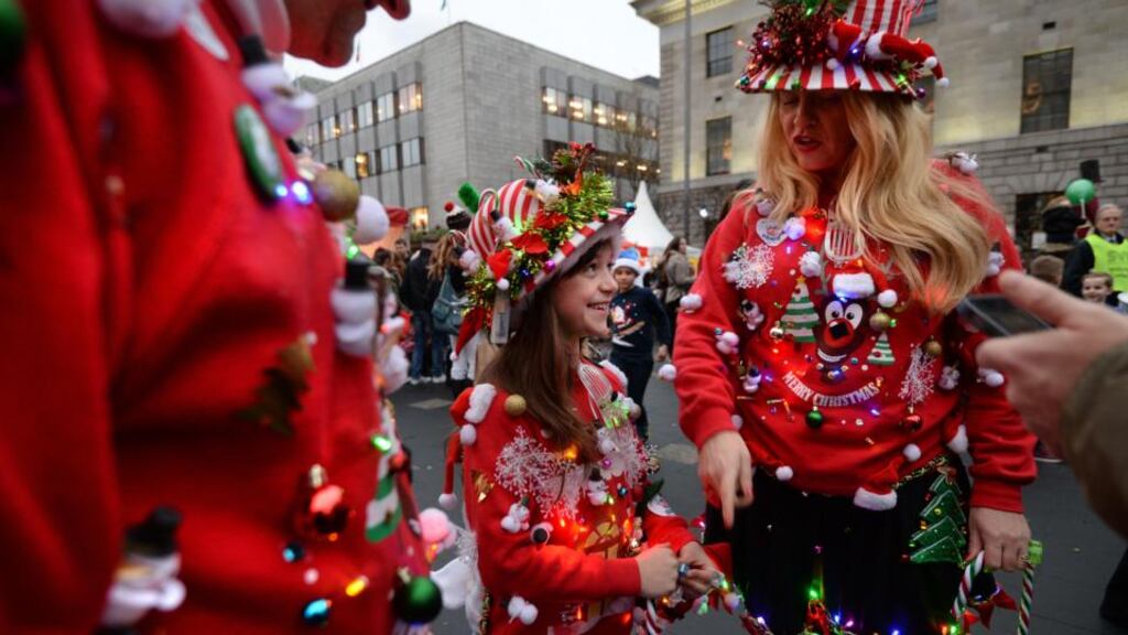 Mark and Frances Hyland from Trim, Co Meath, with their daughter Sarah and dog Lucky, at the Christmas tree lighting ceremony and  successful Geansaí Nollaig  world record attempt on O’Connell Street, Dublin, on Sunday. Photograph: Dara Mac Dónaill/The Irish Times