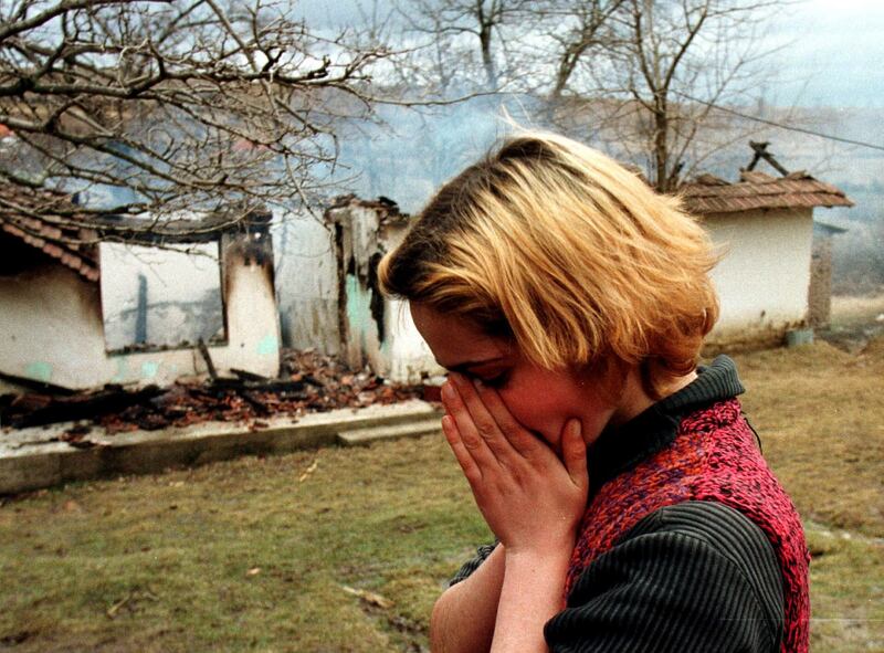 Ethnic Albanian Fluter Pllana (18) cries in front of the burning house of her uncle after Serbian police and troops set fire to the house after encircling and shelling the village of Stitarica in February 1999. Photograph: Reuters