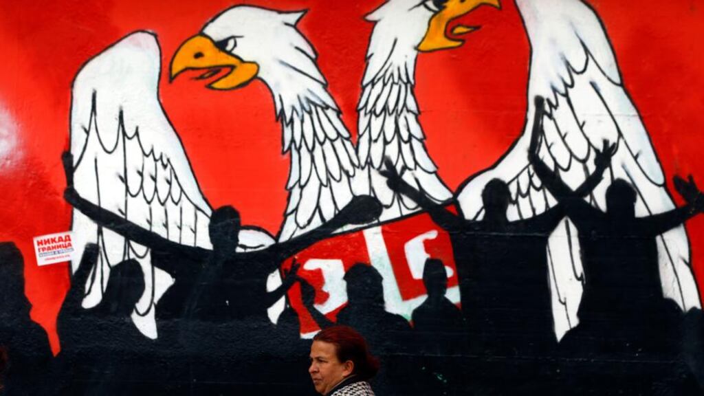 A woman walks past a mural last week depicting part of the Serbian coat of arms in the northern, Serb-dominated part of the ethnically divided town of Mitrovica in Kosovo. Photograph: Marko Djurica/Reuters