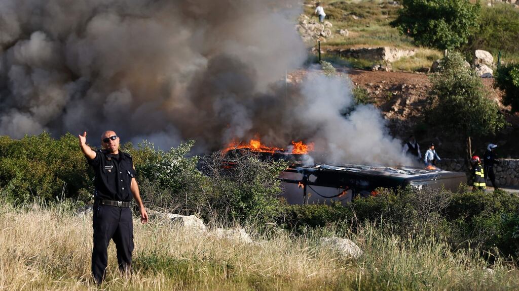 A member of the Israeli security forces gestures to a photographer at the scene of an attack on a bus in Jerusalem. Photograph: Ahmad GharablI/AFP/Getty Images
