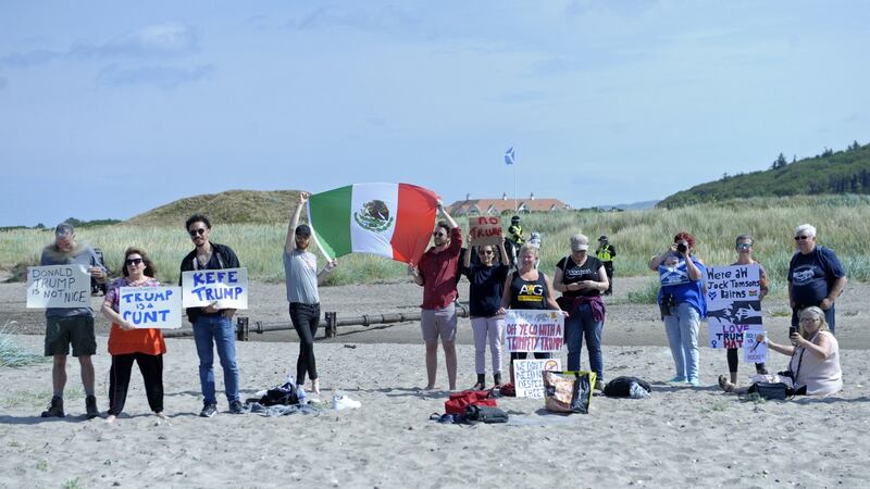 Protesters hold up placards and a Mexican flag on the beach next to Trump Turnberry in Scotland, during the US president’s visit there. Photograph: Andy Buchanan/AFP/Getty Images