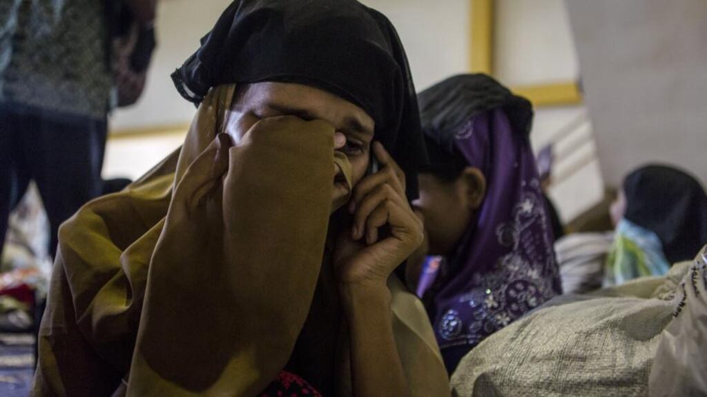 A Rohingya woman weeps as she makes a phone call to her family back in Burma from a shelter in Indonesia. Boats carrying Bumese refugees have gone back out to sea. Photograph: Ulet Ifansasti/Getty Images