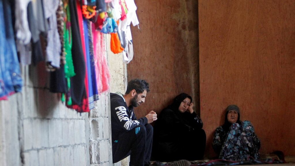 Syrian refugees sit inside a housing compound in Sidon, southern Lebanon. Photograph: Ali Hashisho/Reuters