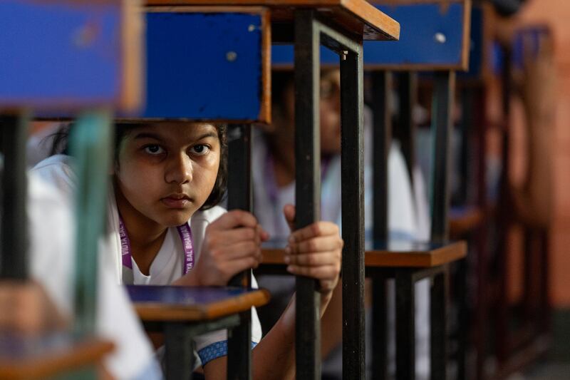 Children take shelter under desks during a civil defence mock drill  in New Delhi, India. Photograph: Anindito Mukherjee/Getty Images