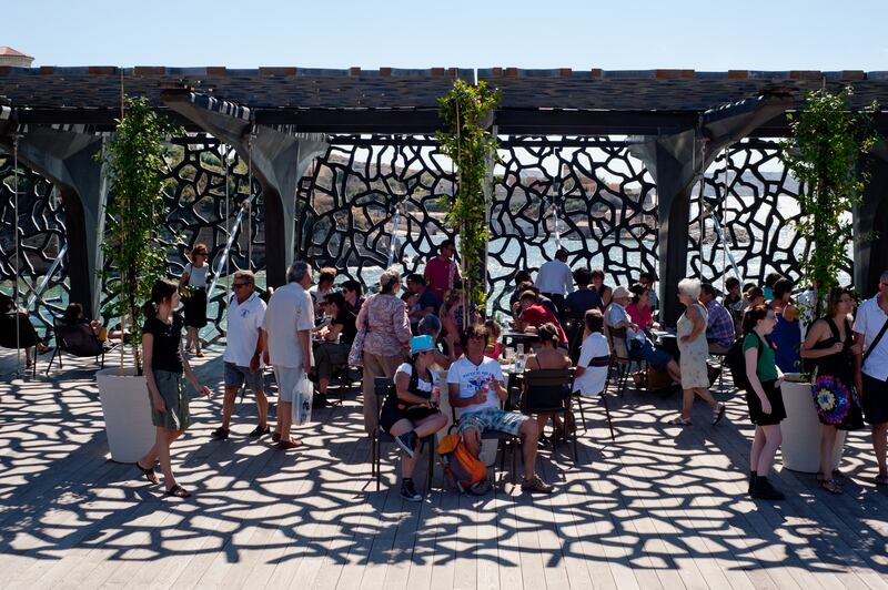 Visitors on the terrace of The Museum of European and Mediterranean Civilizations (MuCEM) in Marseille. The building is surrounded by a latticework shell of fibre-reinforced concrete.
