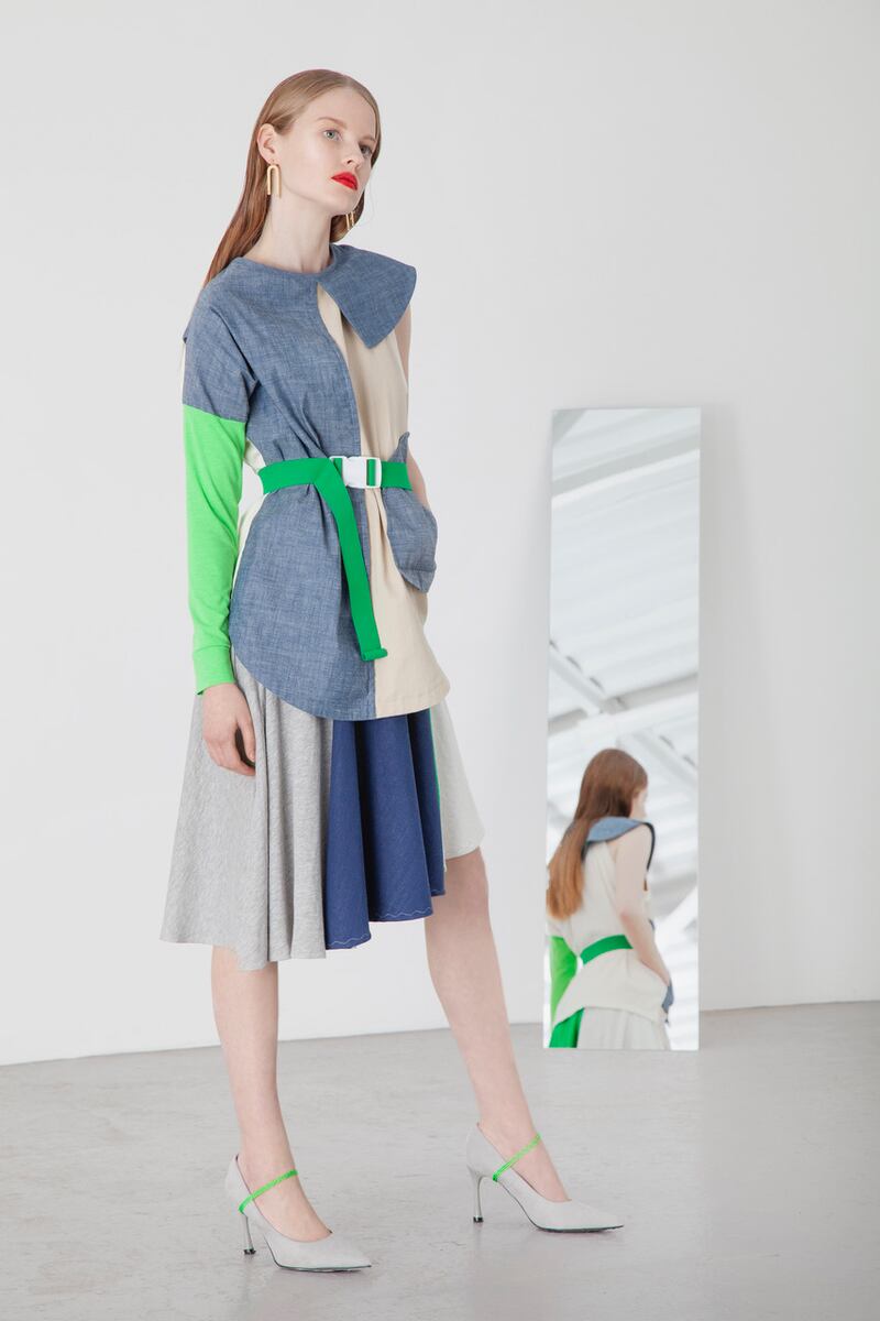 Organic mix top with collar feature and utility pocket €180, organic jersey panelled asymmetric skirt €150, grey suede stilettos €25.95, curved earring €65 Om Diva, belt €24