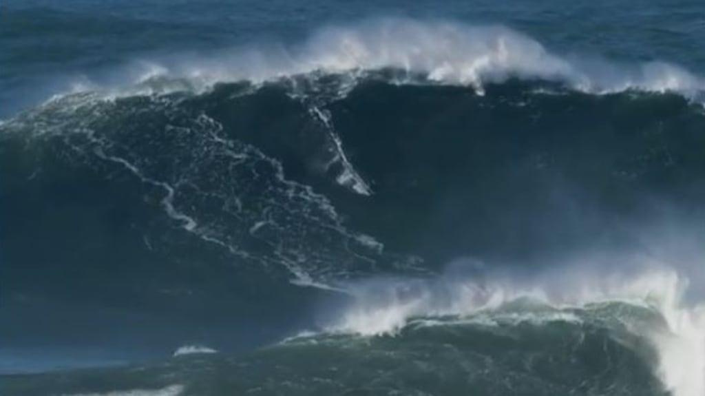 Tom Butler (centre) riding massive wave at at Praia do Norte in Nazaré, Portugal. Photograph: Tom butler/Instagram