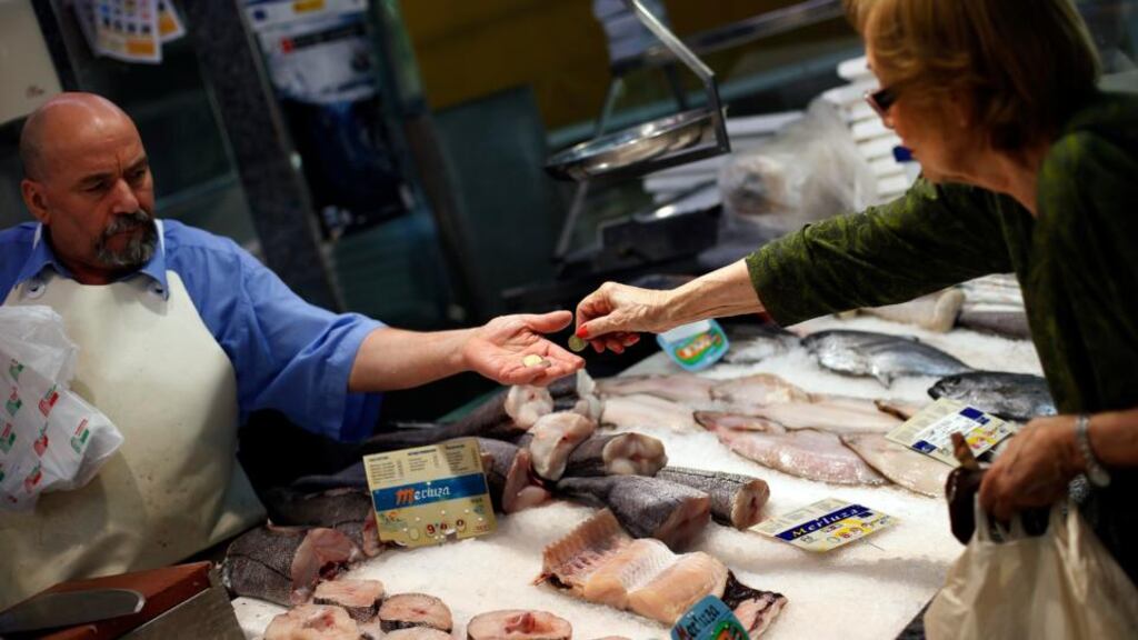 A woman paying for her purchase at a fish shop in central Madrid. Inflation across the industrialised bloc of Organisation for Economic Co-operation and Development (OECD) countries fell to 6.2% in September. Photograph: Susana Vera/Reuters