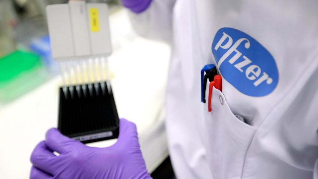 A logo sits on the labcoat of a technician as they work at Neusentis’s research laboratory, a unit of Pfizer , in Cambridge, UK. Photographer: Chris Ratcliffe/Bloomberg