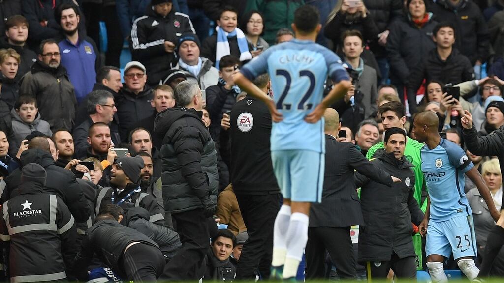 Chelsea’s Cesc Fabregas is helped to his feet after being pushed into the hordings by Manchester City’s Fernandinho during their Premier League clash. Photo: Reuters