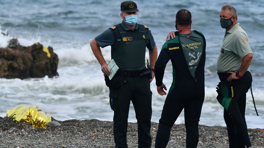 Spanish Guardia Civil members next to the covered body of a deceased migrant at the beach of the Spanish enclave of Ceuta last week. File photograph: Antonio Sempere/AFP/Getty