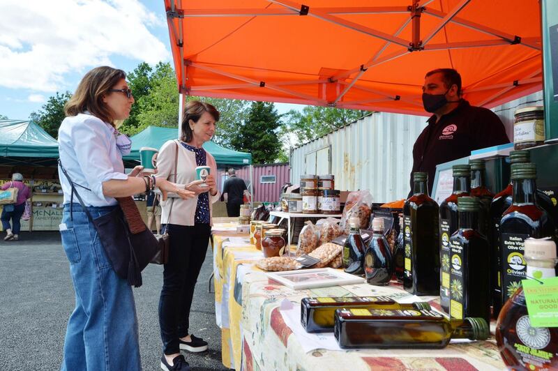 Bernie Tiernan and Anne Marie Finnegan from Donnybrook and Clonskeagh speaking to Lino Olivieri from Olivierioliveoil at the outdoor market at Naomh Olaf GAA in Stillorgan Business Park. Photograph: Alan Betson