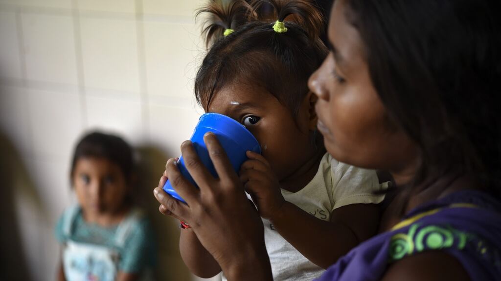Yukpa indigenous children, some of them suffering from malnutrition, are fed with supplements provided by CARITAS organisation, at Los Angeles del Tukuko mission, near Machiques, Zulia state, Venezuela. Photograph: Yuri Cortez/AFP/Getty Images