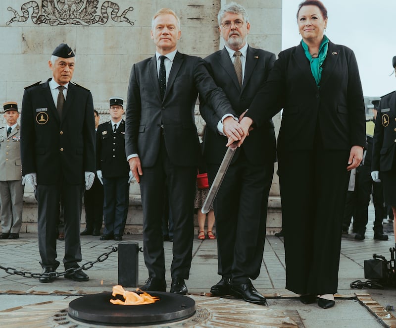 The French ambassador to Ireland Vincent Guerand, the Irish ambassador to France Niall Burgess and Catherine Mulawaka, a descendent of Wolfe Tone, light the eternal flame at the Arc de Triomphe to remember all Irishmen who died in battle fighting with France.