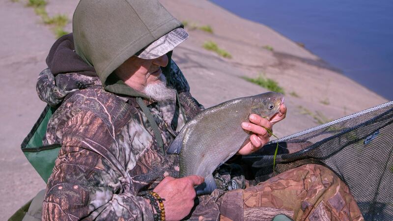 A fisherman displays his catch beside the Nemunas, Lithuania’s longest river