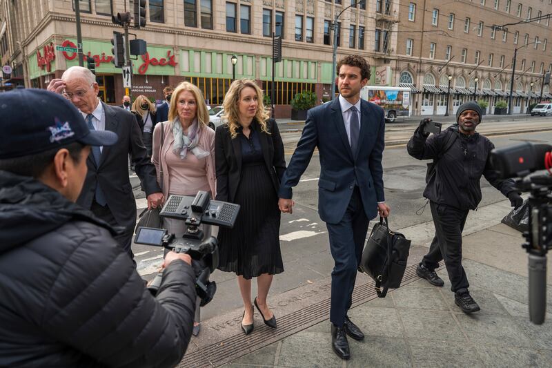 Elizabeth Holmes, centre, walks into federal court in San Jose (Nic Coury/AP)