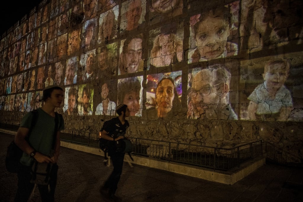 Images of hostages held by Hamas are projected on the outer wall of the Old City of Jerusalem. Photograph: Sergey Ponomarev/The New York Times