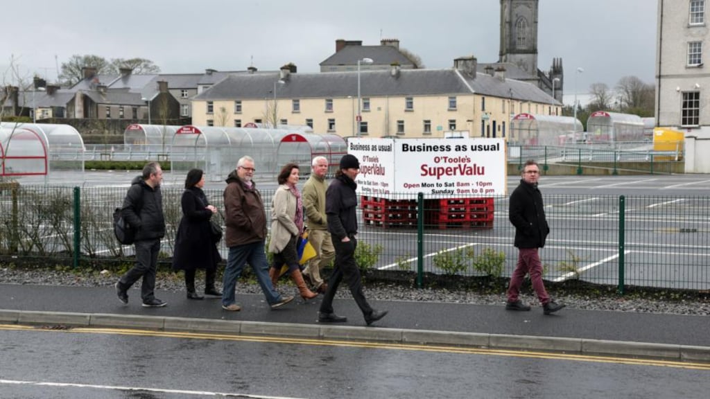 Restore Our Palace Road Group members (from front) Leo Moran Tom Niland, Cllr Shaun Cunniffe, Connie Goss, Steve Lane, Eleanor Joyce and Andy Newman beside the car park at O’Toole’s SupeValu in Tuam. Photograph: Joe O’Shaughnessy.