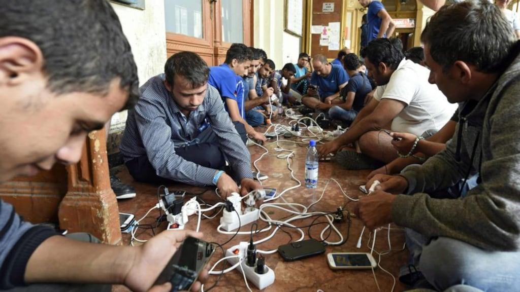 Migrants charging their mobile phones at Keleti railway station in Budapest last week. Photograph: Herbert P Oczeret/EPA