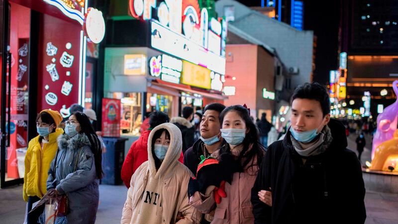 People walk on Jianghan street in Wuhan on Sunday, the eve of the first anniversary of China confirming its first death from the Covid-19 coronavirus. Photograph: Nicolas Asfouri/AFP via Getty Images