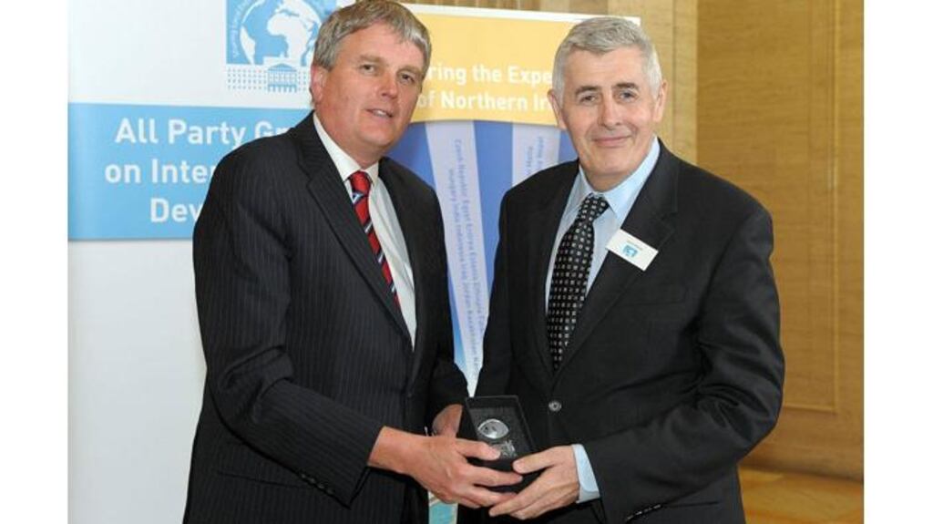 Dominic MacSorley (right) is presented with an award for Outstanding Vocational Commitment to International Development by Jim Wells of the DUP. Photograph: PA