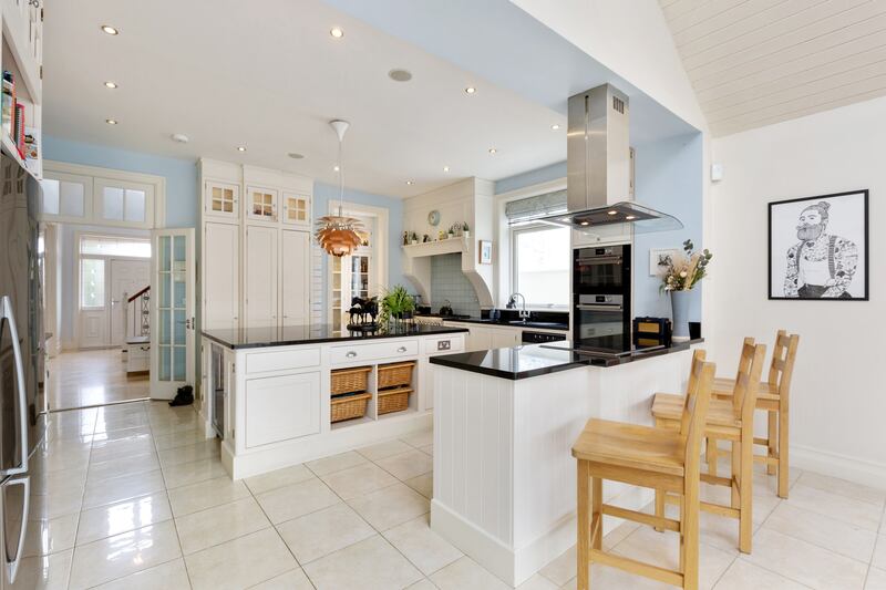 The kitchen is fully fitted with floor-to-ceiling units and top-of-the-range appliances