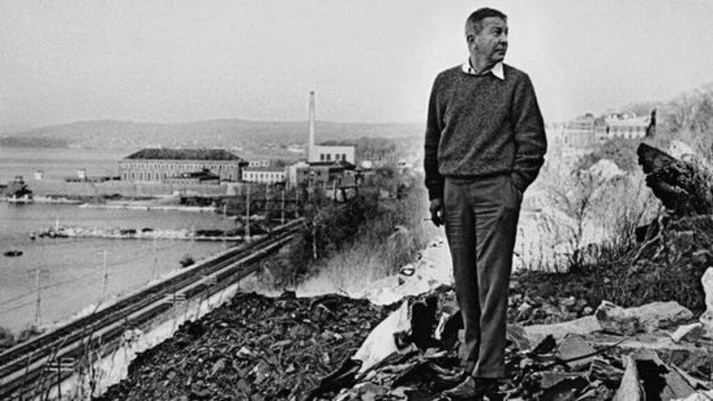 All alone: author John Cheever and his adopted hometown's most famous landmark, Sing Sing prison, at Ossining, New York.