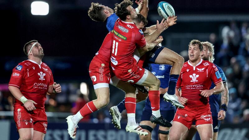 Scarlets’ Gareth Davies and Ryan Conbeer compete in the air with Hugo Keenan. Photo: Dan Sheridan/Inpho