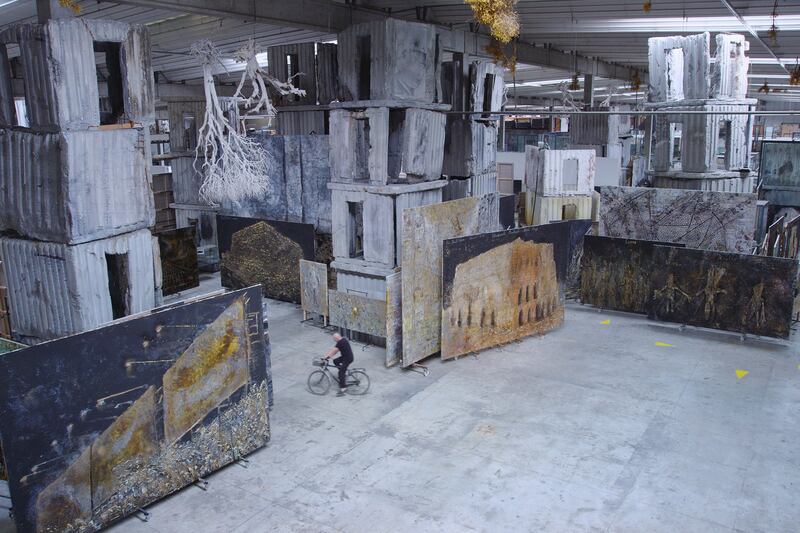 Artist Anselm Kiefer cycles around his warehouse in the film Anselm by Wim Wenders