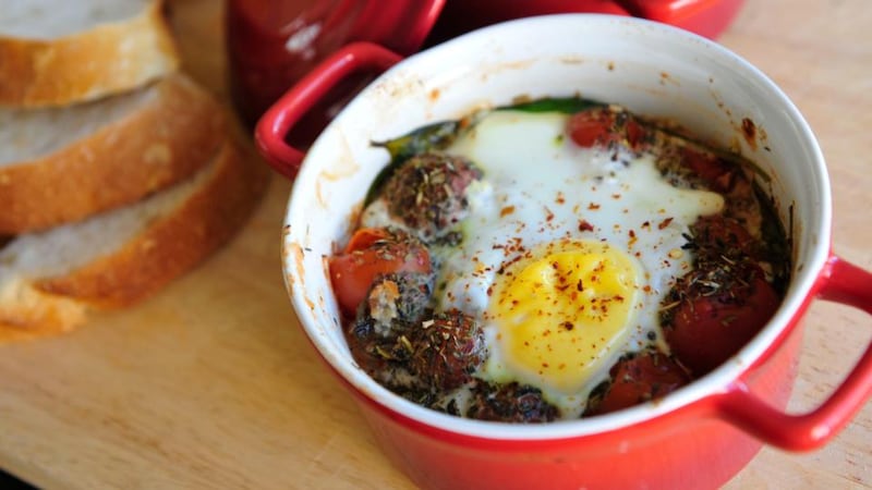 Baked eggs with spinach and tomato. Photograph: Aidan Crawley