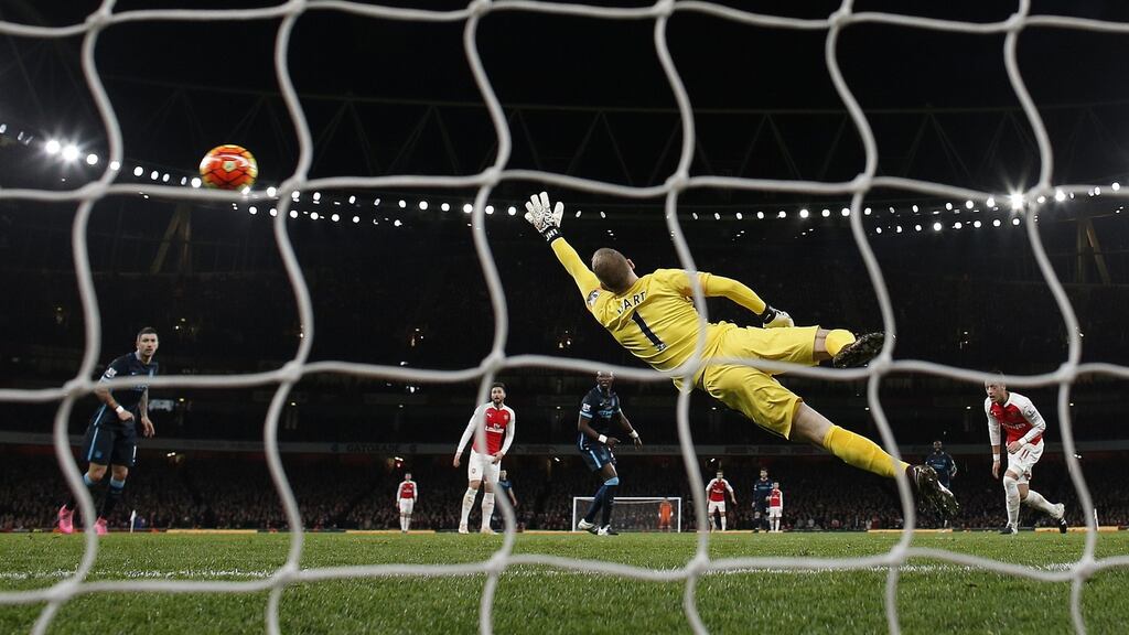 Manchester City’s English goalkeeper Joe Hart fails to stop a shot from Arsenal’s Theo Walcott. Photograph: Getty Images