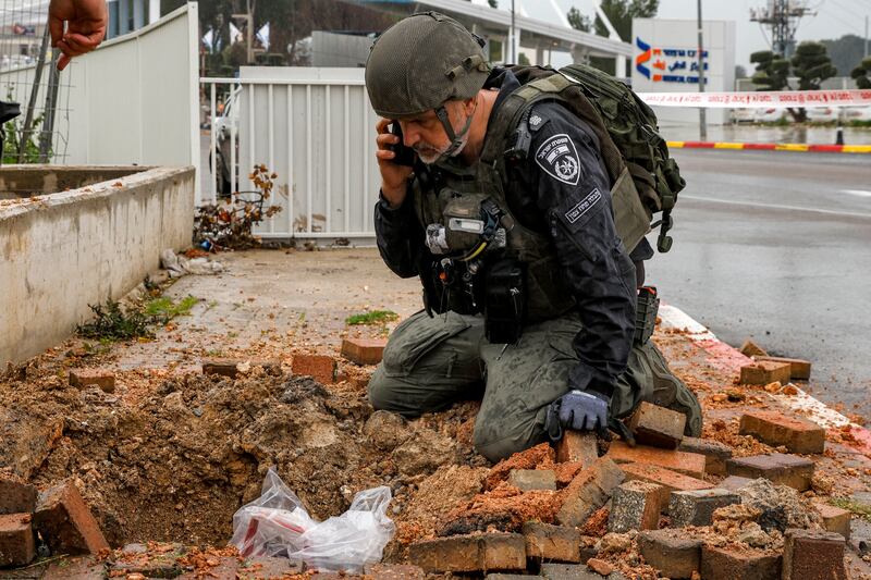 An Israeli policeman inspects the crater left by a rocket fired from southern Lebanon which landed near Ziv hospital in Safed. Photograph: Jalaa Marey/AFP via Getty Images