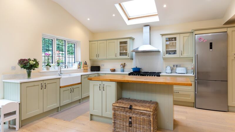 The Noyeks Newmans kitchen has quartz worktops, a timber-topped island unit, polished oak floor with underfloor heating and double doors opening into the rear garden