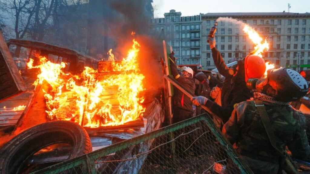 A protester throws a Molotov cocktail during an anti-government protest in downtown Kiev, Ukraine, on January 20th, 2014. Hundreds of protesters carrying clubs and wearing gas masks faced riot police in Kiev a day after 200 people were injured in clashes. Photograph: Sergey Dolzhenko/EPA