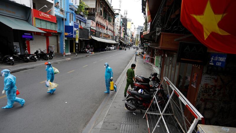 Medical workers collecting test samples from residents walk past in Ho Chi Minh City. Photograph: Huu Khoa/AFP via Getty