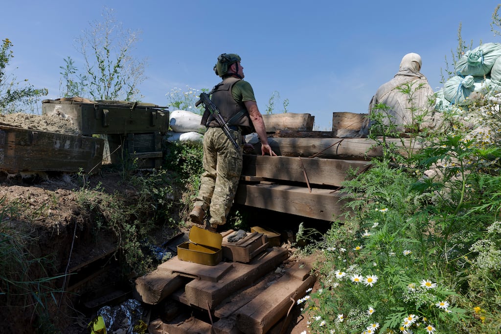 A member of the 24th Mechanised Brigade of the Ukrainian army looks out from a trench next to a dummy soldier at a front-line position near Niu-York in the Donetsk region of eastern Ukraine. Photograph: Tyler Hicks/New York Times