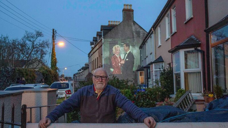 Con Sheehan, self-isolating of Windmill Road, Cork, enjoys a wall projection film shown by Scott Duggan for his neighbours. Photograph: Clare Keogh