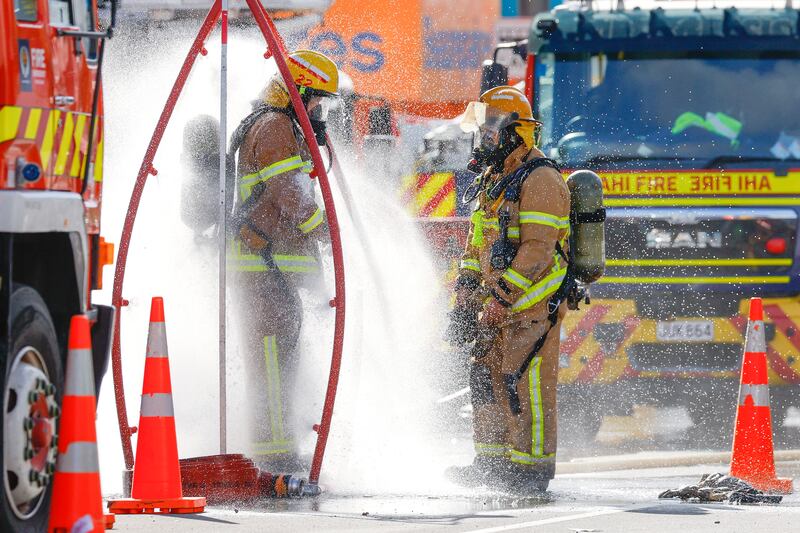 Firefighters rinse off after tackling a fire at a four-storey hostel building in central Wellington, New Zealand. Photograph: Hagen Hopkins/Getty Images
