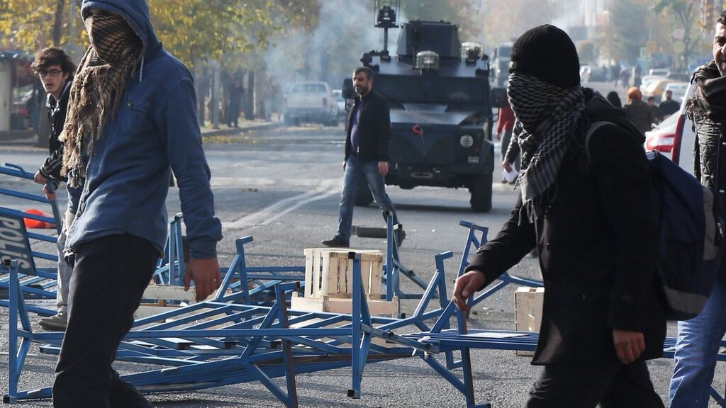 Demonstrators walk past an armoured police vehicle during a protest in Diyarbakir, Turkey. Photograph: Sertac Kayar/Reuters