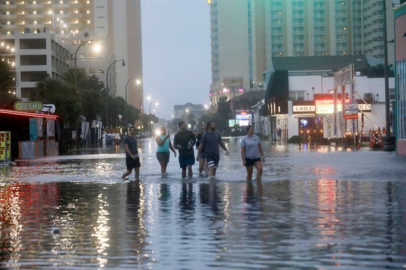 People walk up a flooded Ocean Boulevard in North Myrtle Beach, South Carolina after the passage of Hurricane Idalia. Photograph: Jason Lee/The Sun News/AP