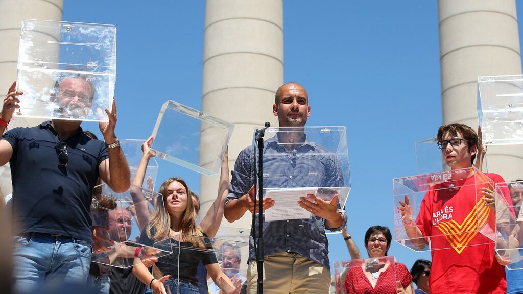 Manchester City manager Pep Guardiola holds a ballot box during a pro-independence rally in Barcelona. Photograph: Albert Gea/Reuters