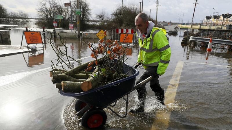 Athlone resident Brendan Grehan pushes a wheel barrow through flood water in Athlone, Co Westmeath on Sunday. Photograph: Brian Lawless/PA Wire