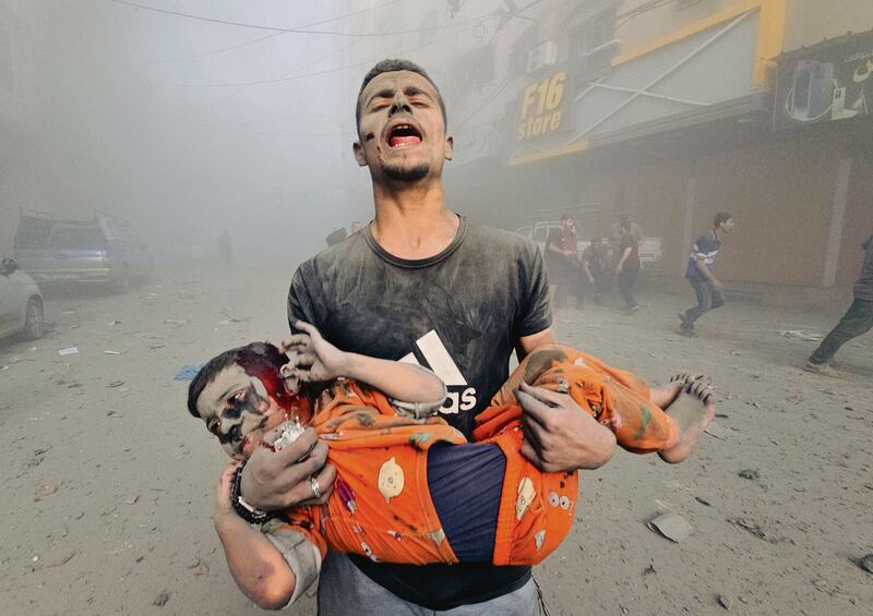 A man carries an injured Palestinian child as Israeli attacks continue at Jabalia refugee camp in Gaza City. Photograph: Stringer/Anadolu/Getty Images