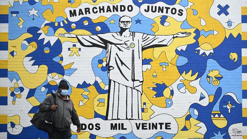 A pedestrian walks past a graffiti mural of Leeds United manager Marcelo Bielsa. Photo: Oli Scarff/AFP via Getty Images
