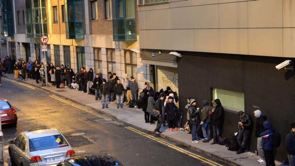 People queue on Poolbeg Street waiting for the Garda National Immigration Bureau to open on Burgh Quay. Photo: Cyril Byrne/The Irish Times