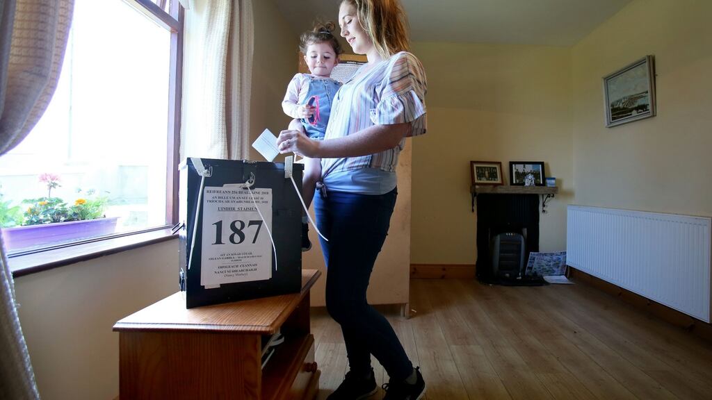 Colleen Ui Fhioruisce with her two-year-old daughter Saoirse, at the ballot box as she votes on Gola Island, off the Donegal coast. Photograph: Paul Faith/AFP/Getty Images